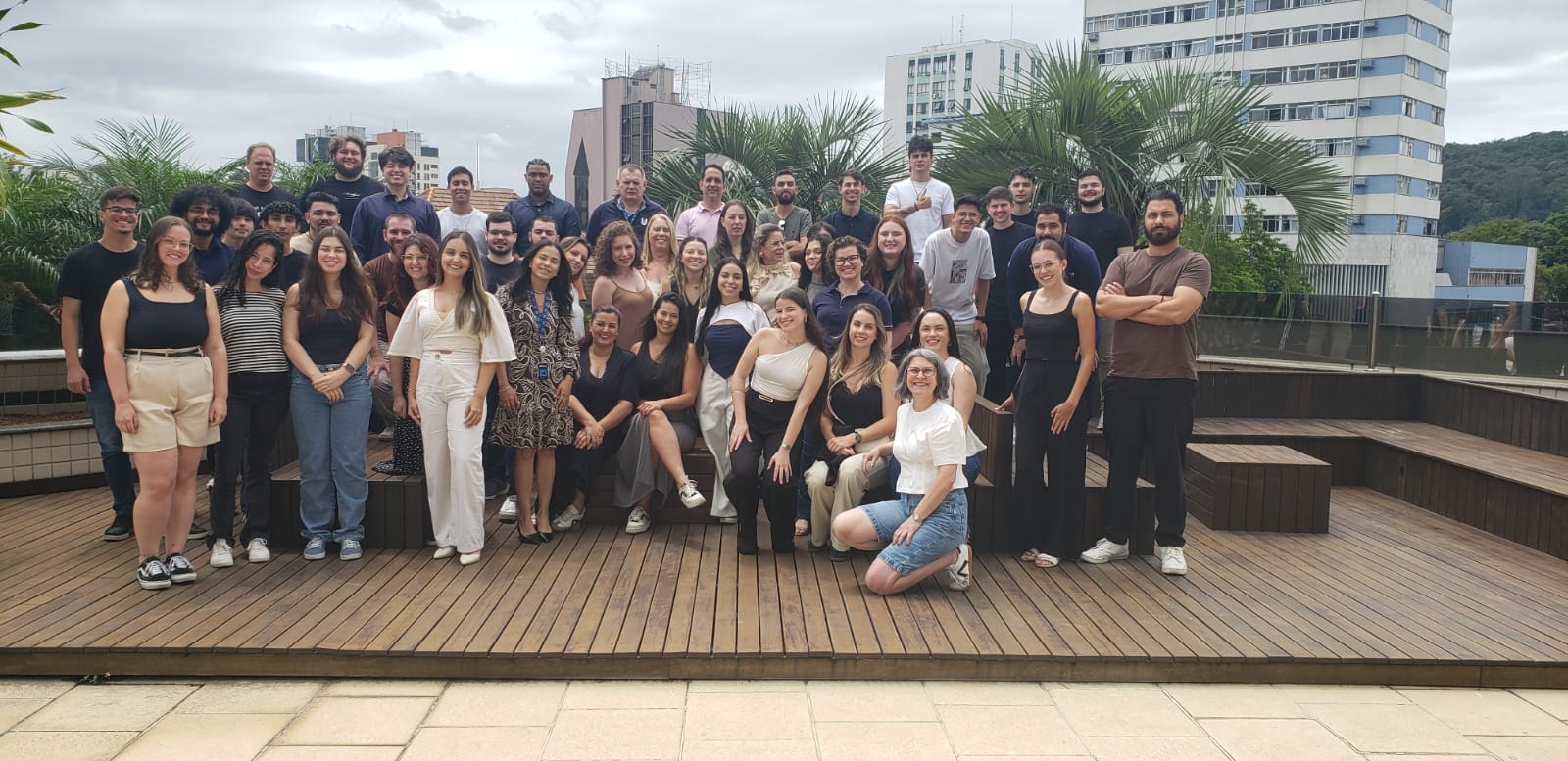 O time da Ultra LIMS reunido em um terraço, com prédios e palmeiras ao fundo